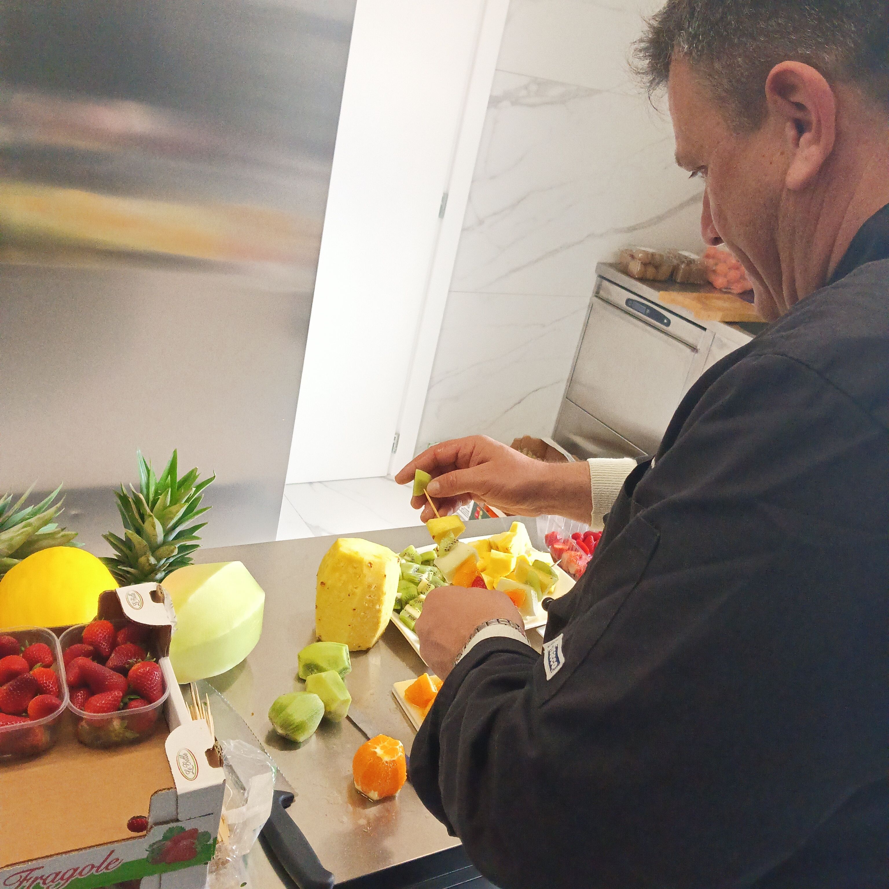 A person preparing fruit on a kitchen counter with a window in the background.