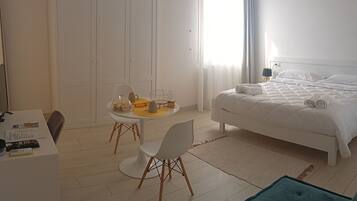 Une chambre d’hôtel moderne équipée d’un lit, d’un bureau et d’un coin repas.