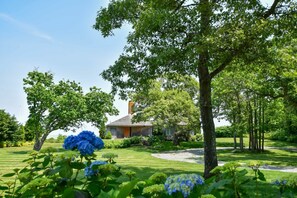 A house surrounded by lush greenery and a well-maintained lawn. - Panoramic Water Views w/ Private Beach! (Chatham)