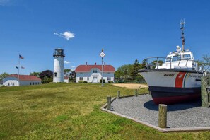 A lighthouse, a U.S. Coast Guard boat, and a building with a red roof. - Panoramic Water Views w/ Private Beach! (Chatham)