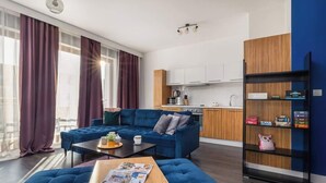 Una sala de estar moderna con un sofá azul, una mesa de centro de madera y una estantería.