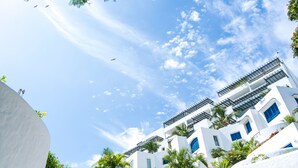 A white building with multiple balconies and a clear blue sky. - Excelente vista Casa Blanca - Same  (Tonchigüe)