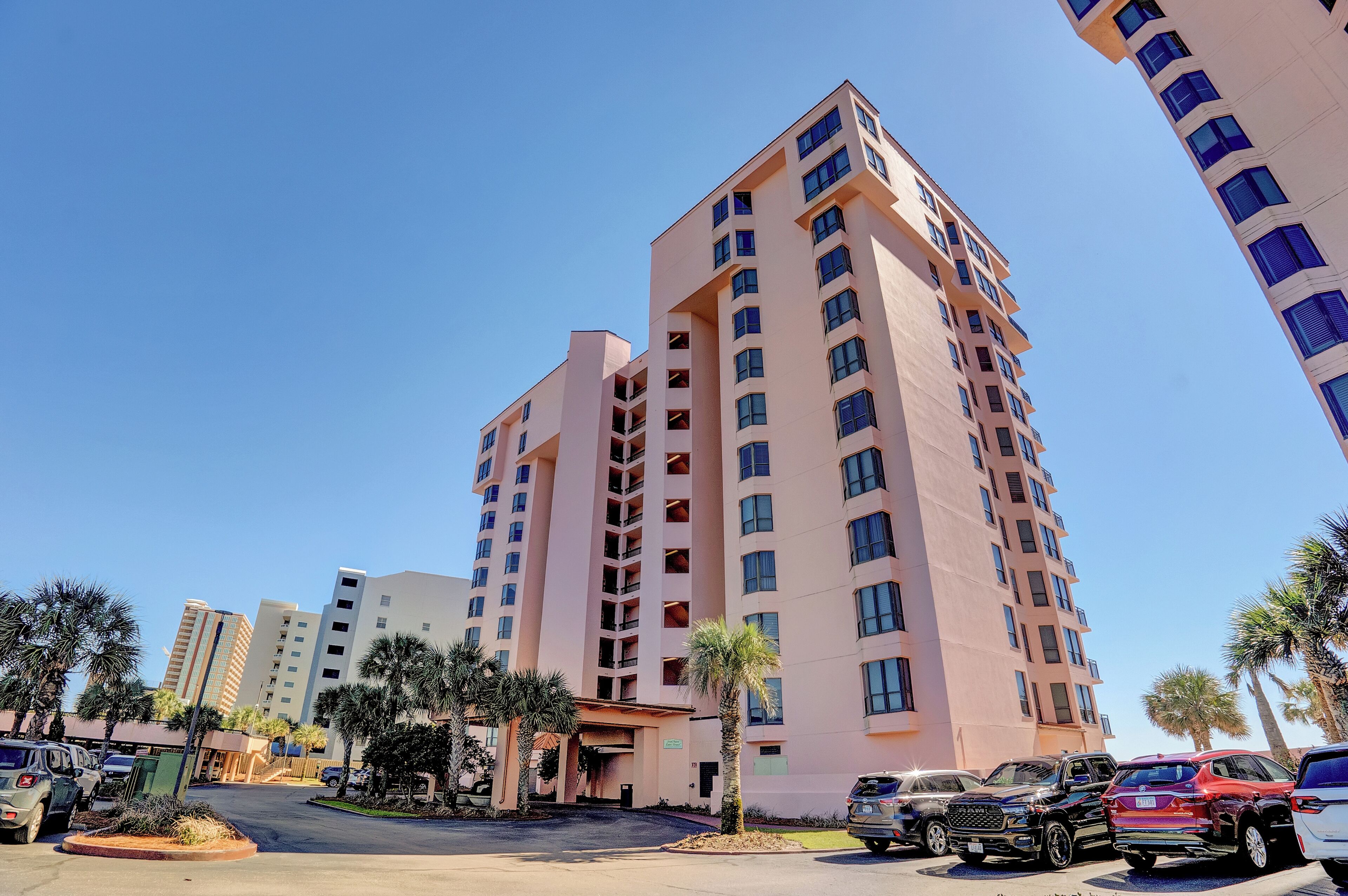 A multi-story hotel with a modern design, featuring a central entrance and multiple balconies.