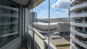A modern building with a curved facade, large windows, and a view of a cityscape. - Slavic Industrial Apartment by CHORS (Bratislava)