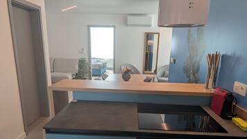Una cocina moderna con estufa integrada, encimera de madera y un armario azul.