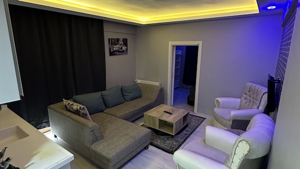 A modern living room with a sofa, armchair, and coffee table. - Zirve Suit Rezidans (Talas)