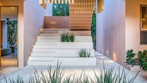 A modern staircase with a minimalist design, surrounded by greenery and a well-lit interior. - Stunning Studio Tulum Jungle w/ Pool Restaurant (Tulum)