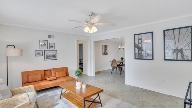 A modern living room with a sofa, coffee table, and dining area. - Residency Savannah  (Savannah)
