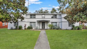 A two-story house with a front entrance, a small front yard, and a pathway leading to the door. - Residency Savannah  (Savannah)