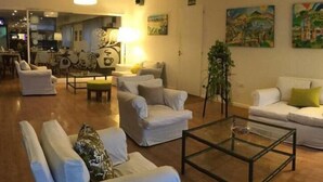 Amplia sala de estar con un conjunto de sofás, una mesa de centro y una planta en maceta.