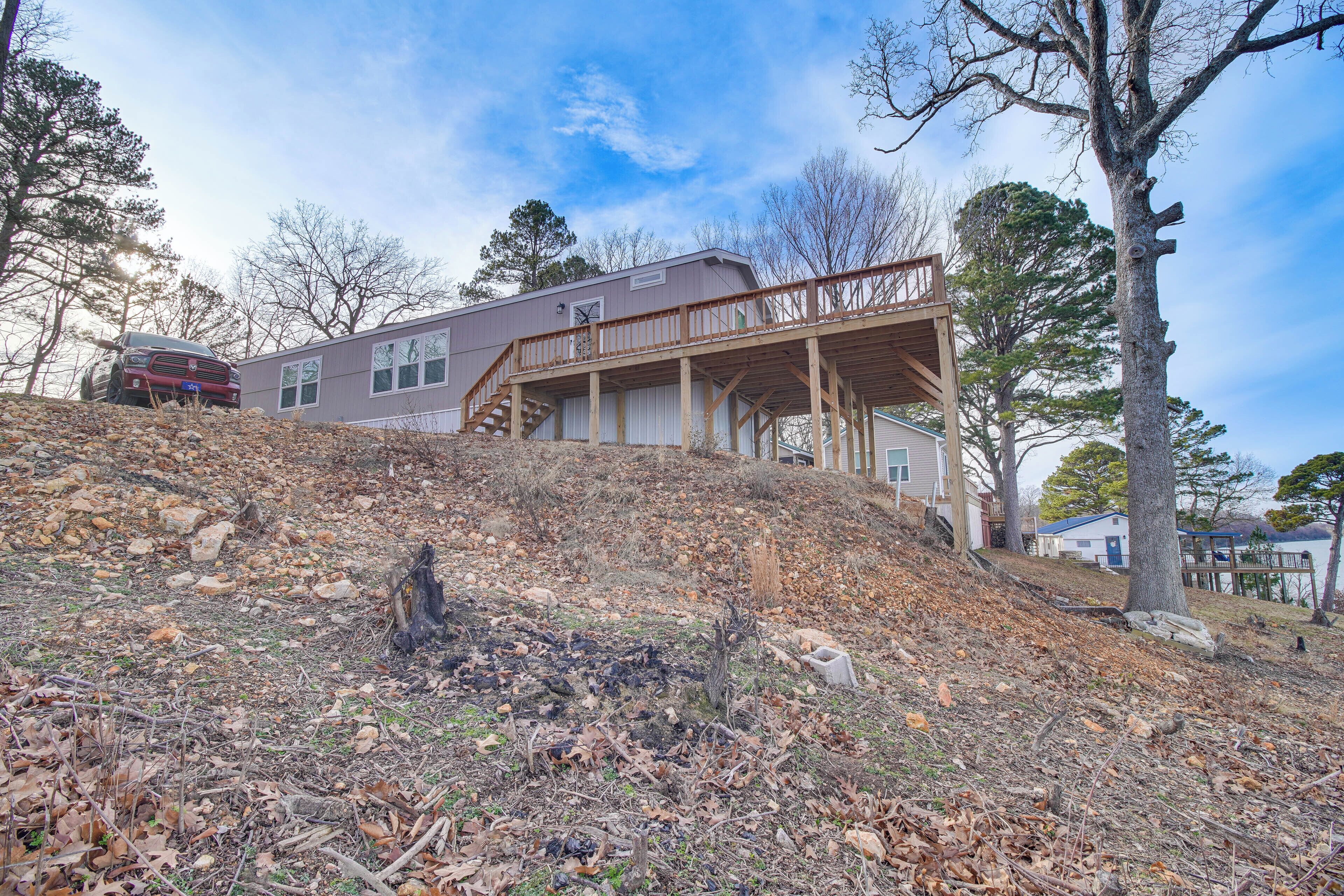 A two-story house with a wooden deck and a staircase leading to the second floor.