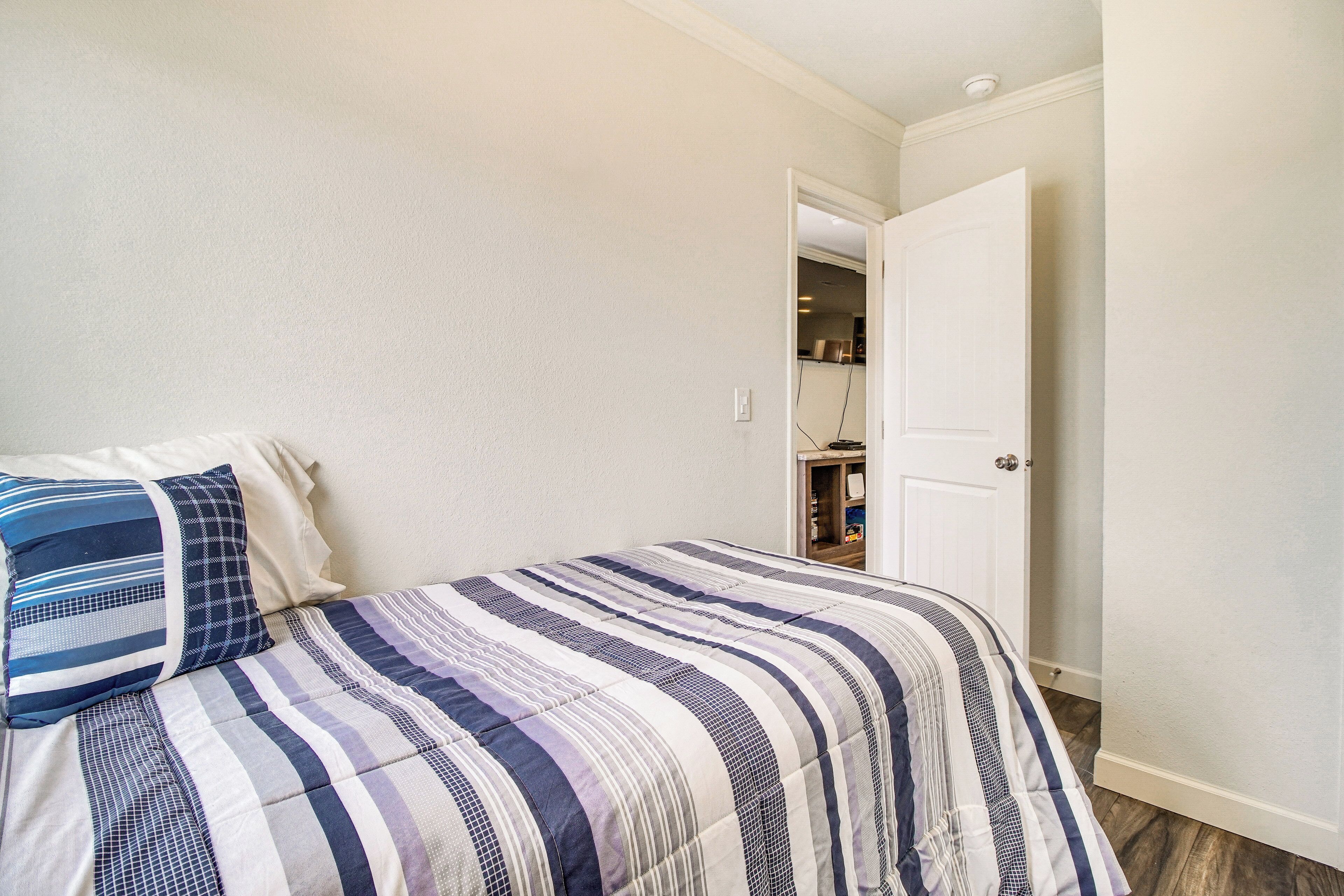 A bedroom with a bed, a door, and a closet.