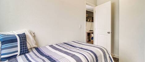 A bedroom with a bed, a door, and a closet.