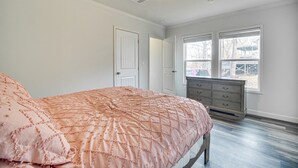 Une chambre à coucher avec un lit, une commode et une fenêtre équipée de stores.