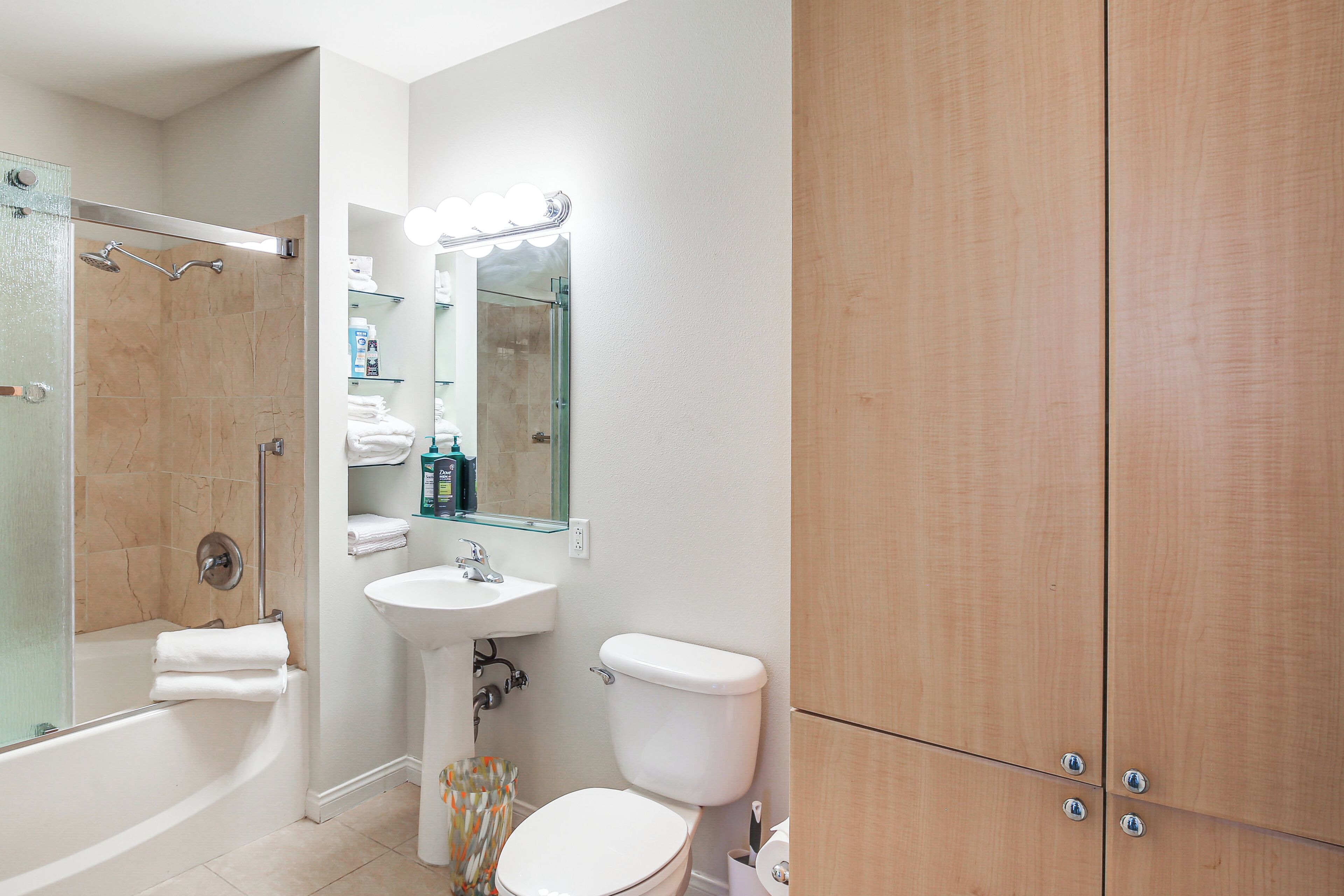 Une salle de bain avec une baignoire, un lavabo, des toilettes et des meubles en bois.