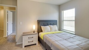 A bedroom with a bed, bedside table, and a window. - Brand New Spring Home < 1 Mi to Old Town! (Spring)