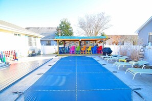 A trampoline area with colorful chairs and a small building with a blue roof. - Twin Tree Road 511 3 Bedroom Home by RedAwning (Ocean City)