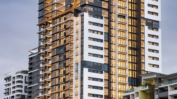 A high-rise hotel with multiple balconies, a modern architectural design, and a prominent Riverside Hotel sign. - Charming Urban Retreat (South Brisbane)