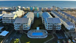 A beachfront hotel with multiple-story buildings, a central swimming pool, and ocean views. - Beach Access, Lagoon, Fishing Pier and Pool (Gulf Shores)