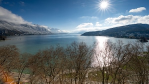 A panoramic view of a lake with mountains in the background and a clear sky. - Le Panoramic - Magnifique Vue sur le lac d'Annecy (Annecy)