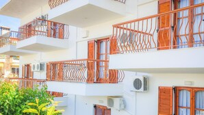 A multi-story building with balconies, air conditioning units, and wooden shutters. - Apartments Eytyxia (Kassandra)