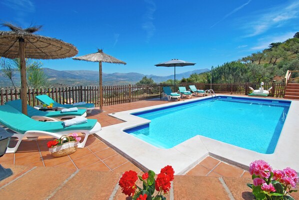 Un espace piscine comprenant des chaises longues, une piscine et une vue sur les montagnes.