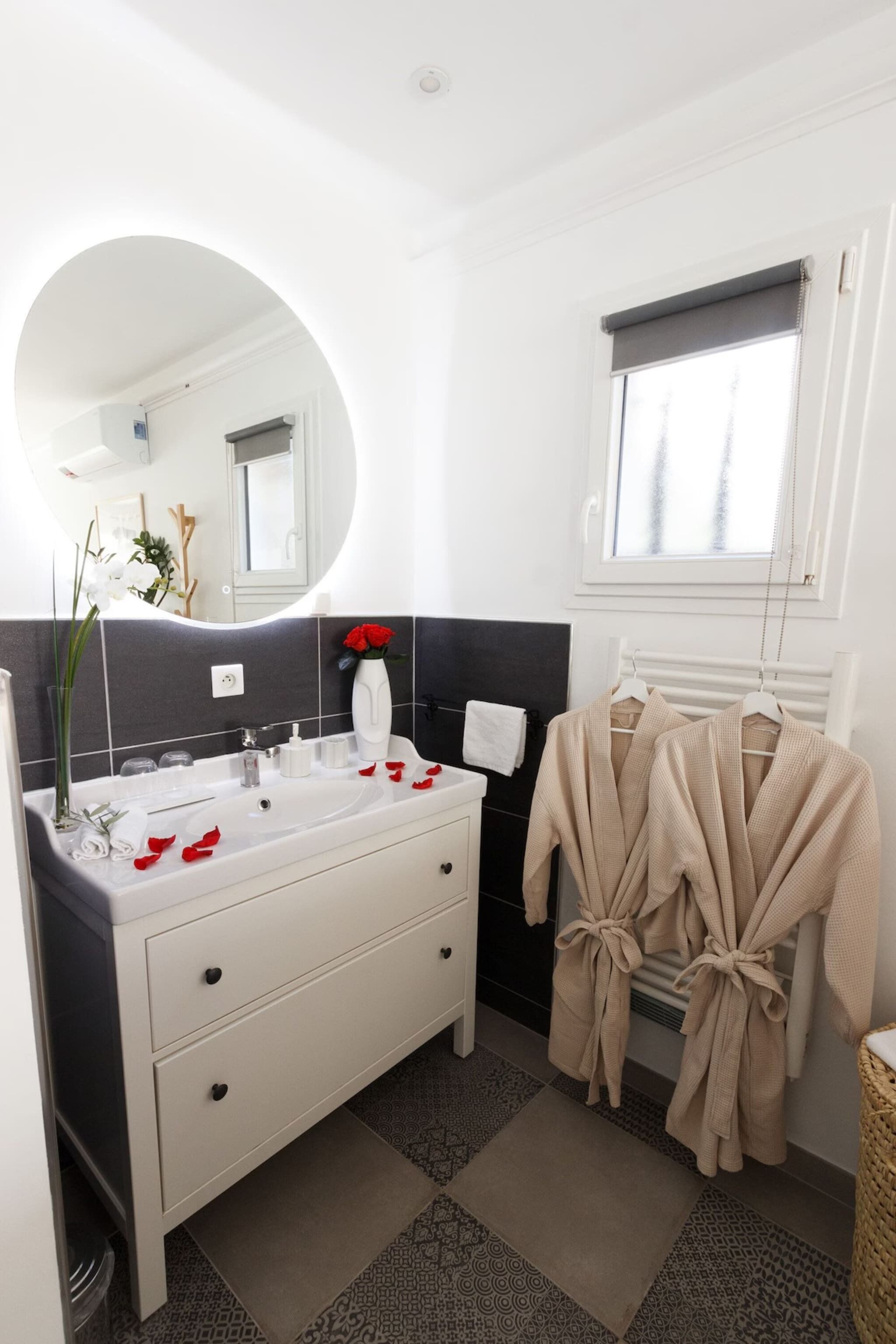 A bathroom with a white vanity, a mirror, and a towel rack.