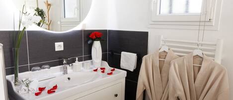 A bathroom with a white vanity, a mirror, and a towel rack.