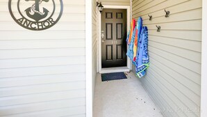A hallway with a door marked '111', a metal anchor sign, and colorful towels hanging on the wall.