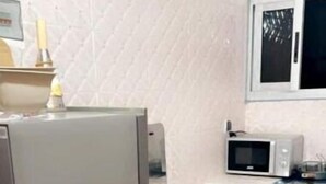 Eine Küche mit einem Edelstahlkühlschrank, einem Gasherd und einer Mikrowelle.
