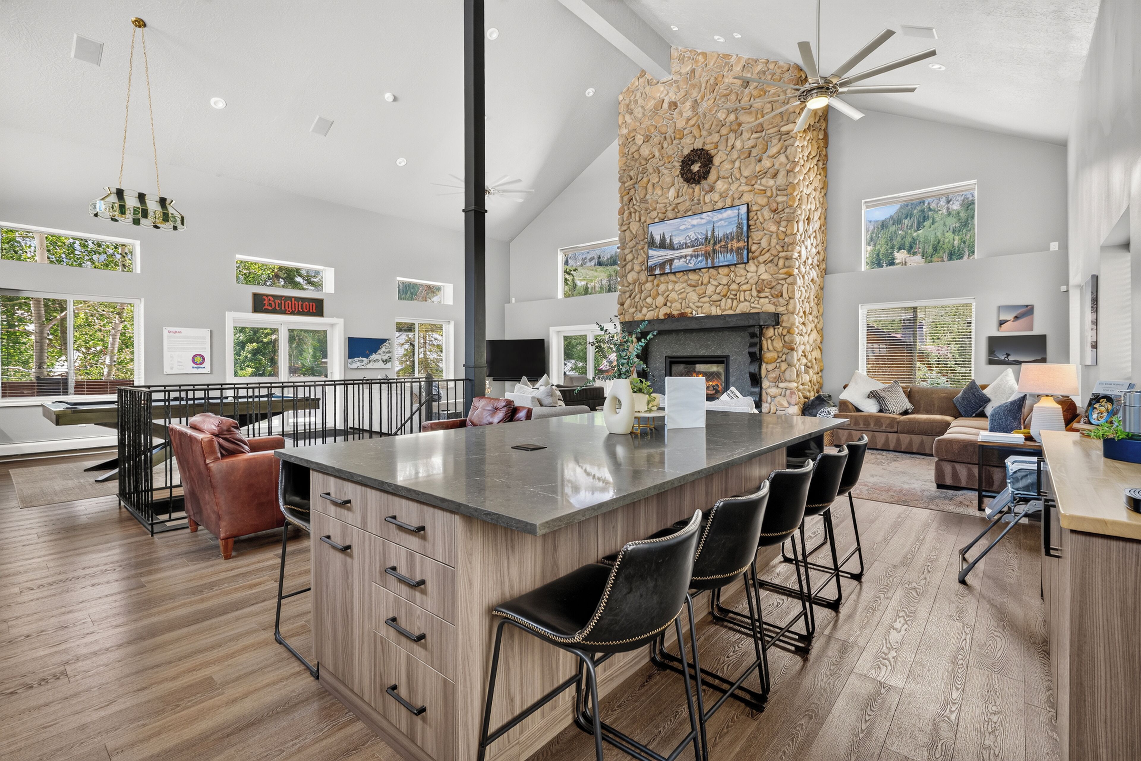 A spacious living area with a central island, a fireplace, and a stone accent wall.