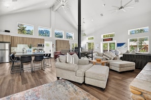 A spacious living area with a large sofa, a dining table, and a kitchen area with modern appliances.