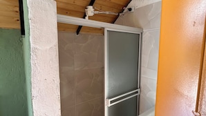Una cocina pequeña y compacta con techo de madera, refrigerador empotrado y salpicadero de azulejos.