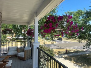 A covered porch with wicker furniture and hanging flower baskets. - Capital City- 6 Miles from Madison with fireplace (Sun Prairie)