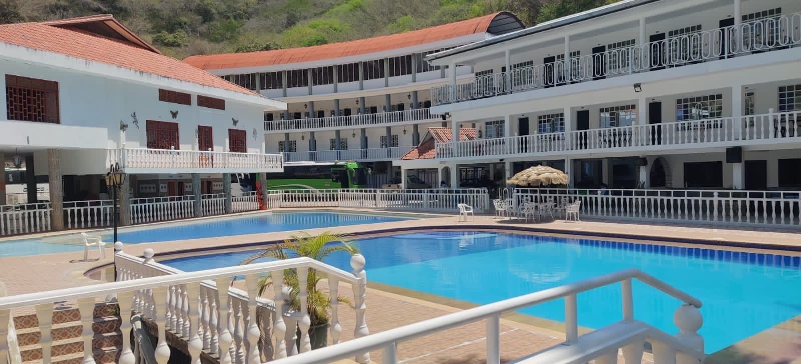Un hôtel doté d’une piscine centrale, de nombreux balcons et d’une cour intérieure.