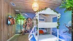 A children's room with a bunk bed, a mural of a tropical scene, and a television on the wall. - The Ultimate 9bd Disney Getaway - The Best Arcade - Private Pool  (Kissimmee)