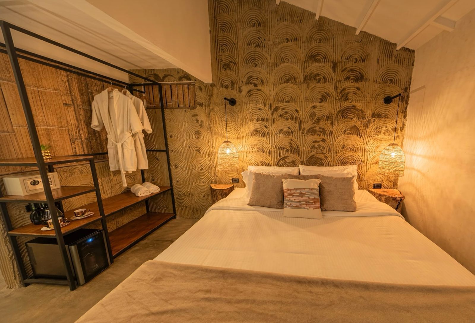 Une pièce comprenant un lit, une étagère avec des serviettes, un mur en bois et deux lampes fixées au mur.