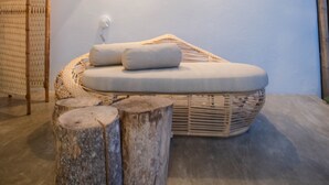 Un spa moderno con un área de asientos circular, taburetes de madera y una lámpara fijada a la pared.