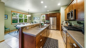 Una cocina moderna con armarios de madera, electrodom ésticos de acero inoxidable y una isla grande.