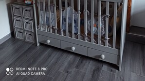Una cuna blanca con techo de madera y luces colgantes.