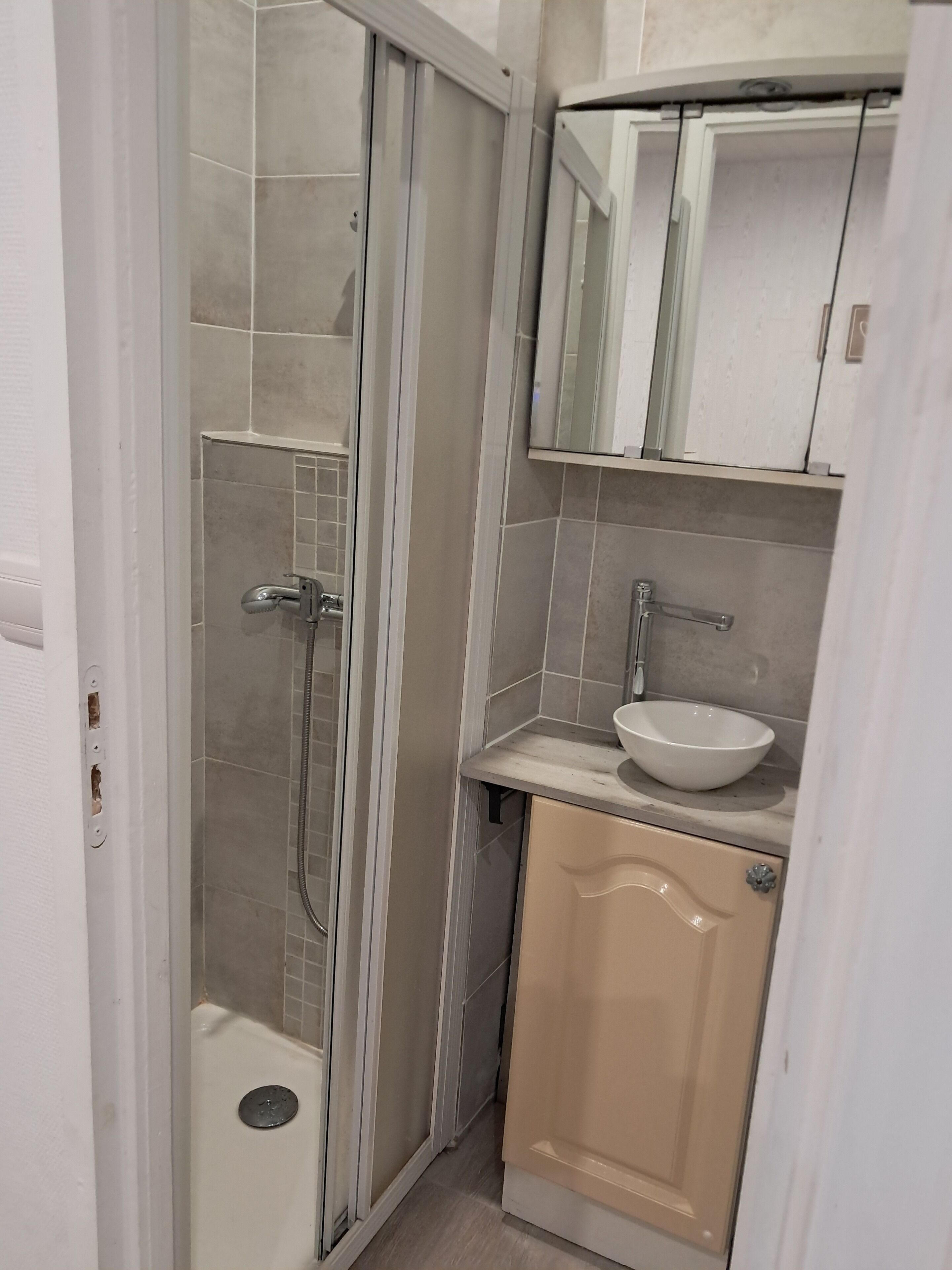Un baño con ducha de mampara, lavabo y mueble.