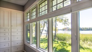 A room with a large window overlooking a grassy area and a body of water. - Serene Lakefront Home On Lake Minnetonka (Excelsior)