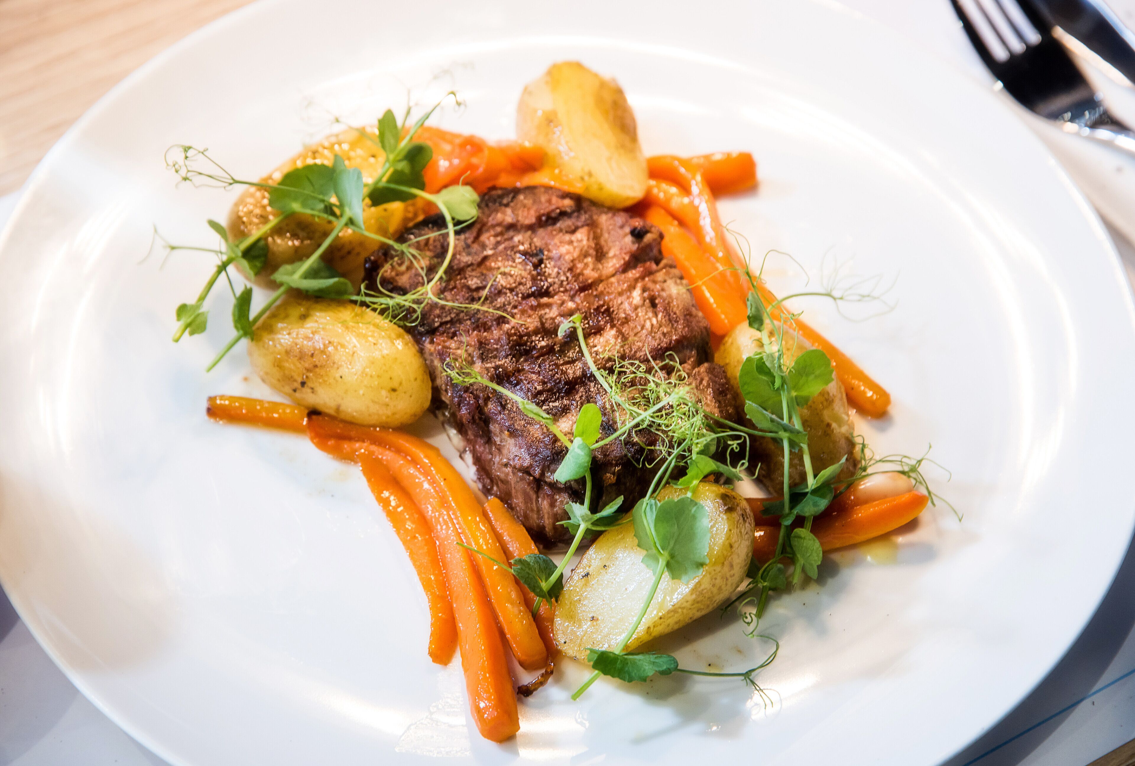 A plate with a steak, carrots, and potatoes.