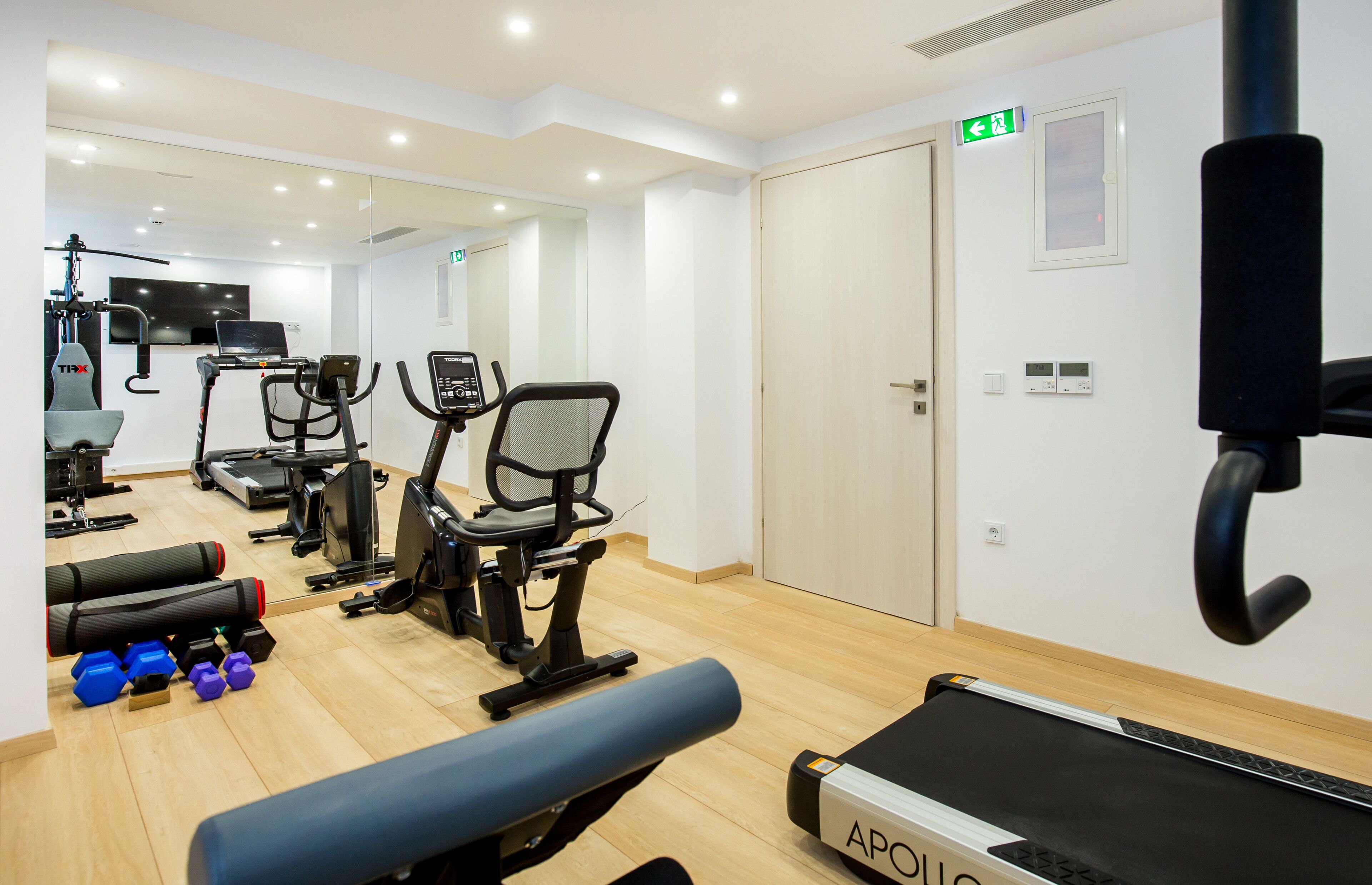 A gym with exercise equipment, a bench, and a treadmill.