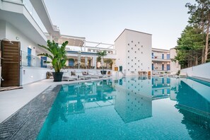 Une piscine intérieure avec des chaises longues et une plante en pot.