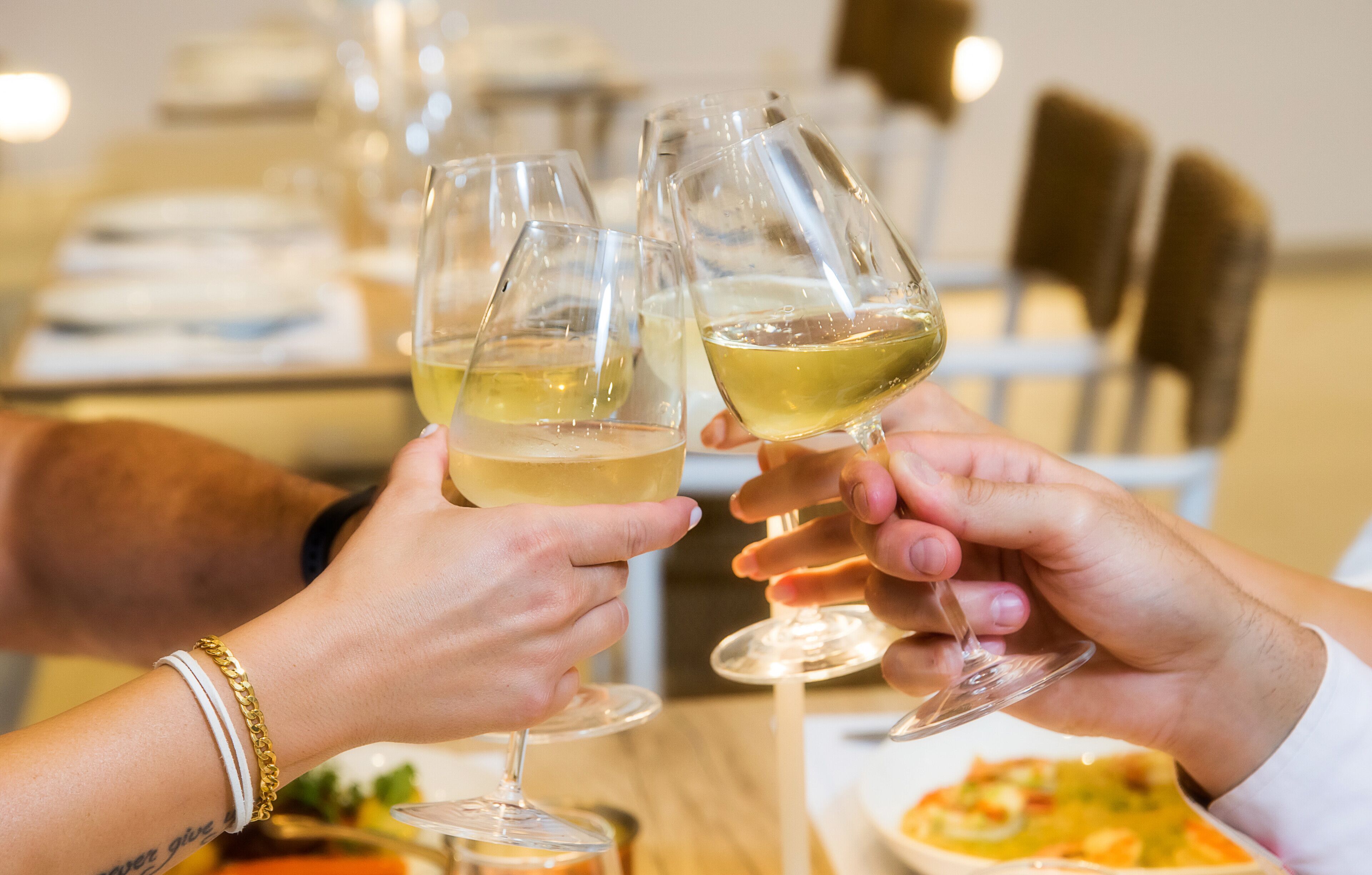 Two people clinking wine glasses.
