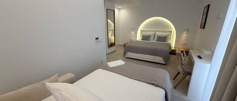 Habitación de hotel moderna con una cama grande, un escritorio y un elemento decorativo en una pared curva.