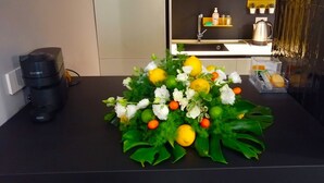 A kitchen counter with a coffee machine, a decorative fruit and flower arrangement, and a shelf with kitchen items. - Trstevere Boutique Suite Roma with Turkish bath (Roma)