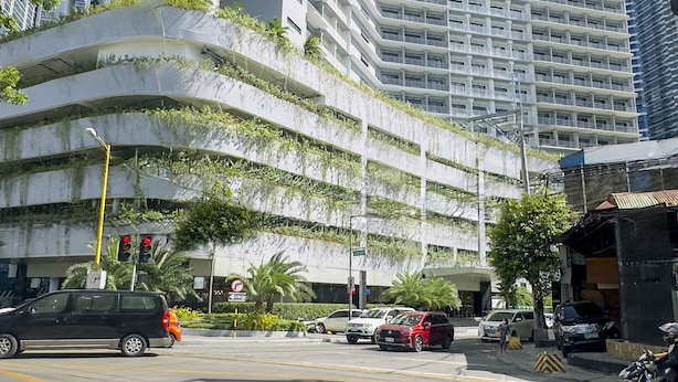 Un immeuble moderne de grande hauteur, doté de nombreux balcons et d’une façade incurvée.