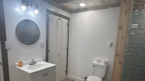 Une salle de bain comprenant un lavabo, des toilettes et un espace douche.